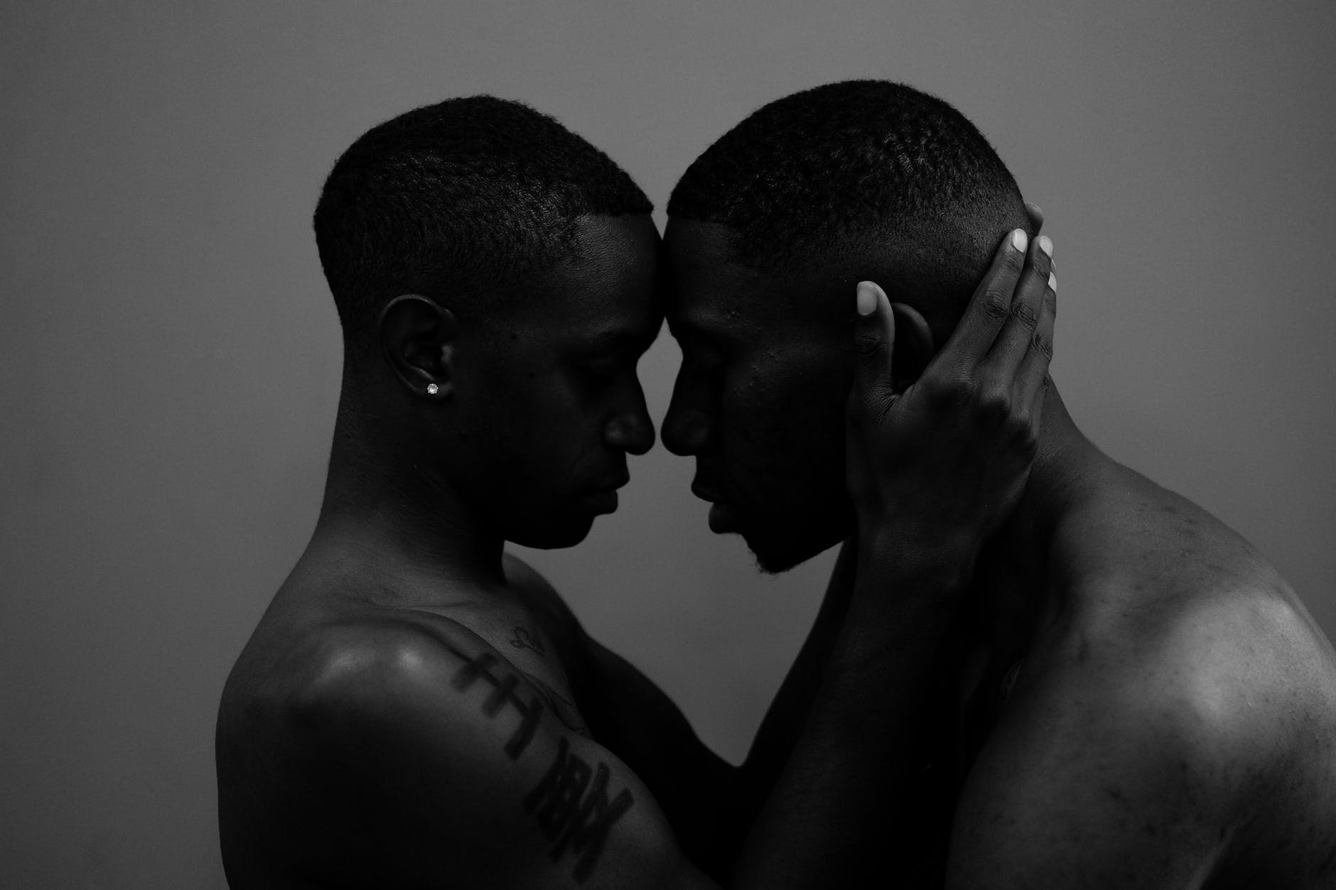 grayscale photo of woman holding man head